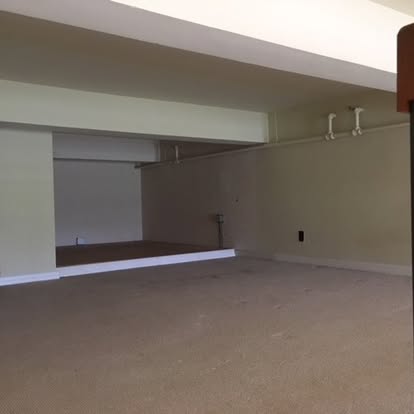Empty retail or commercial space with concrete floor and white walls