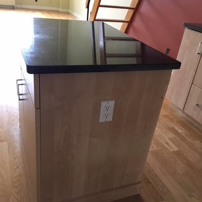 Kitchen island with stainless steel top and wood base with electrical outlet