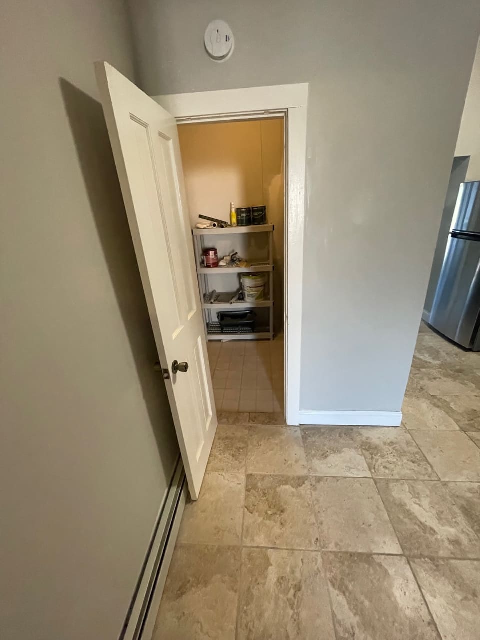 Open pantry closet with shelving and storage items in kitchen