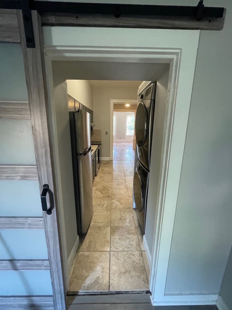 Galley kitchen with stainless steel appliances and tile flooring viewed from doorway